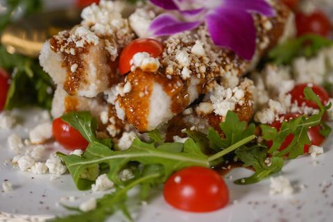 Close-up of the Baku crispy eggplant salad with sesame seeds, goat cheese, cherry tomatoes and arugula